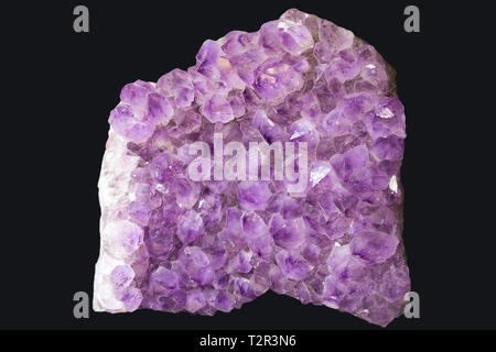 Large piece of living raw amethyst at the minerals exhibition isolated on black background Stock Photo