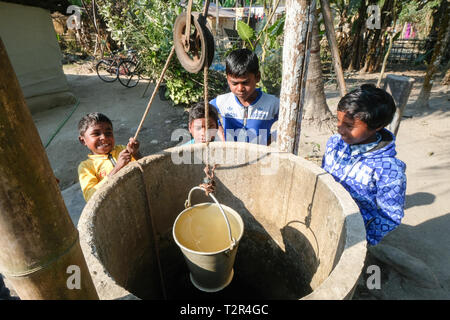 Children draw water from a well in Amdanga Village, Assam, India Stock Photo