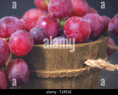 Rose grapes in wooden bucket on a woden table Stock Photo