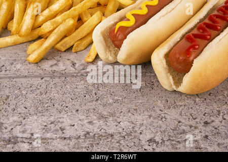 Duo of hot dogs and french fries on table. Fast food restaurant concept. Close up. Stock Photo