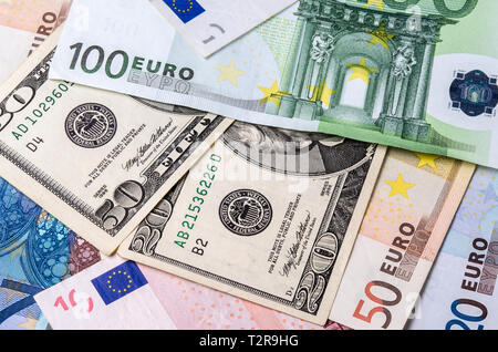 Euro banknotes and American Dollars bills of various denominations close-up. Stock Photo