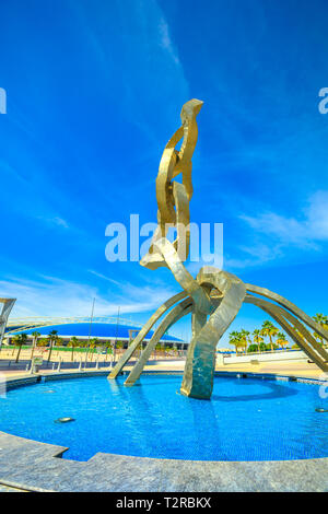 Doha, Qatar - February 21, 2019: Olympic rings monument at Aspire Zone in Doha Sports City with Aspire Dome or Aspire Academy on background. Vertical  Stock Photo