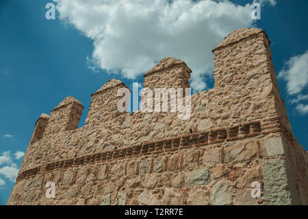 Battlement with merlons and crenels over rough stone wall encircling the town at Avila. With an imposing wall around the gothic city center in Spain. Stock Photo