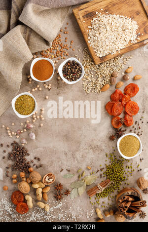 Dried fruits cereals spices and nuts organic healthy snacks on a textural background. The concept of healthy eating. Lenten products. Frame under the  Stock Photo