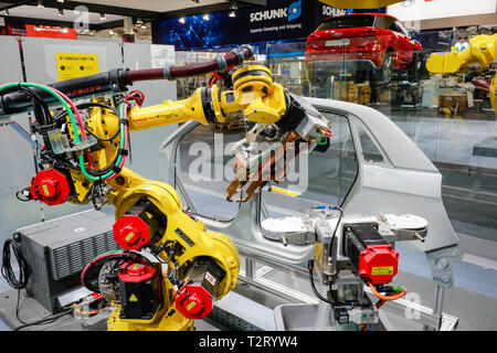 Hanover, Lower Saxony, Germany - Hanover Fair, industrial robots welding and transporting cars at the Fanuc booth. Hannover, Niedersachsen, Deutschlan Stock Photo