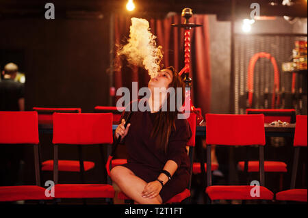 Asian girl smoke hookah at lounge bar. Stock Photo