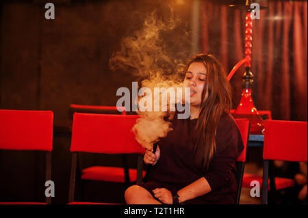 Asian girl smoke hookah at lounge bar. Stock Photo