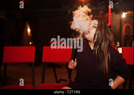 Asian girl smoke hookah at lounge bar. Stock Photo