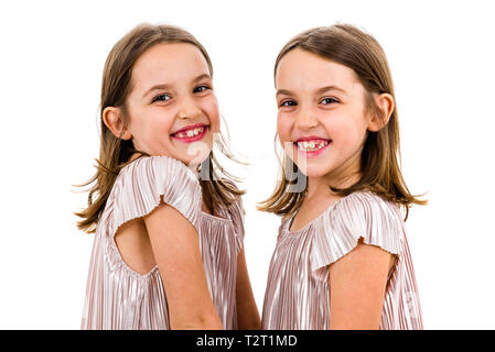 Identical twin girls sisters are posing for the camera Happy twin