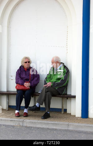 A pair of retired older couple having a conversation seated together. Stock Photo