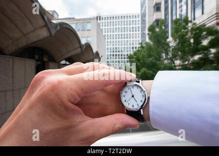 Caucasian man wearing a wrist watch showing the time 5:00 Stock Photo