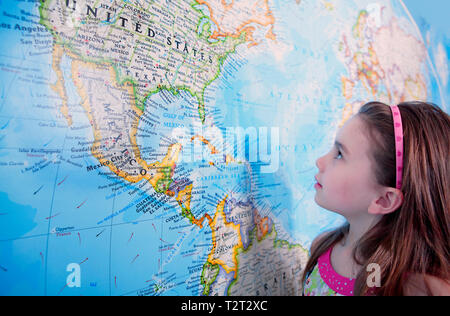 A young caucasian girl looking at the USA on a large map Stock Photo