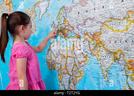 Pre teen caucasian girl pointing to Europe on a map Stock Photo