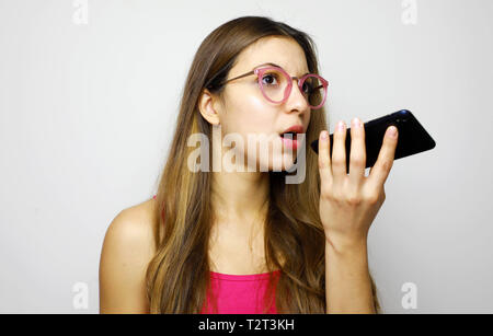 Serious girl using voice recognition app on smart phone Stock Photo