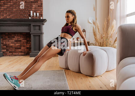 In living room. Busy businesswoman working out in the living room having no time for gym Stock Photo