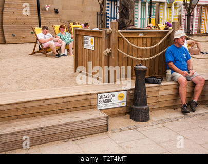 People relaxing on deck chairs at the Quayside Seaside premises by the banks of the River Tyne at Newcastle upon Tyne Stock Photo