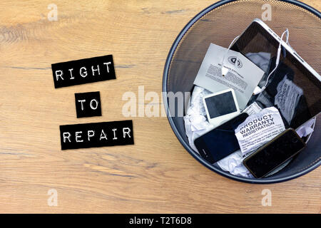 broken smart phone and smashed tablets in rubbish bin with warranties and guarantee, right to repair concept, warranties invalidated Stock Photo