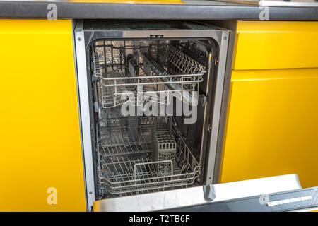 opened dishwasher in the yellow kitchen Stock Photo
