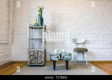 table, chairs, shelves on the background of a white brick wall in vintage loft interior Stock Photo