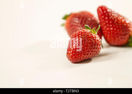 Close-up of three strawberries isolated on white background shot in high angle view with selective focus Stock Photo