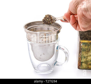 Putting tea leaves in tea strainer Stock Photo