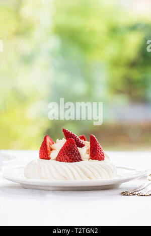 Table Set for Morning Tasty Breakfast made of Mini Pavlova Meringue Cake with Fresh Strawberries on white background Stock Photo