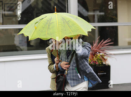 Glamorous racegoers on a wet & windy at Aintree, Liverpool, Merseyside, UK. 4th April 2019.  The famous horse racing Grand National Randox Health event welcomes fashionistas & street style people on this very special parade of the finest expensive female fashions.  Credit: MediaWorldImages/Alamy Live News Stock Photo