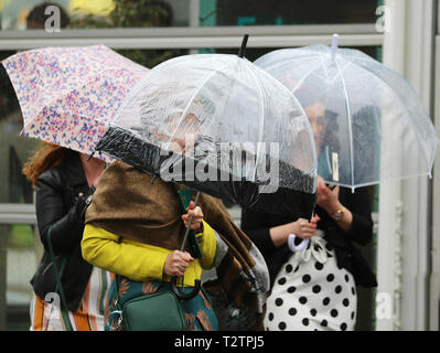 Glamorous racegoers on a wet & windy at Aintree, Liverpool, Merseyside, UK. 4th April 2019.  The famous horse racing Grand National Randox Health event welcomes fashionistas & street style people on this very special parade of the finest expensive female fashions.  Credit: MediaWorldImages/Alamy Live News Stock Photo