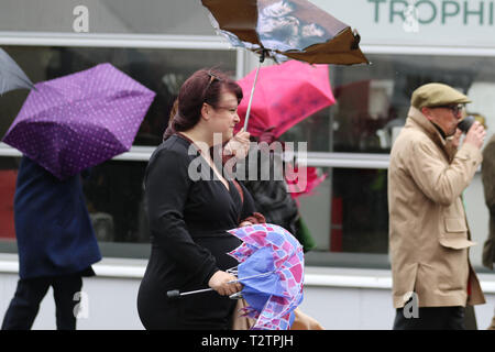 Glamorous racegoers on a wet & windy at Aintree, Liverpool, Merseyside, UK. 4th April 2019.  The famous horse racing Grand National Randox Health event welcomes fashionistas & street style people on this very special parade of the finest expensive female fashions.  Credit: MediaWorldImages/Alamy Live News Stock Photo