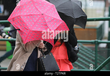 Glamorous racegoers on a wet & windy at Aintree, Liverpool, Merseyside, UK. 4th April 2019.  The famous horse racing Grand National Randox Health event welcomes fashionistas & street style people on this very special parade of the finest expensive female fashions.  Credit: MediaWorldImages/Alamy Live News Stock Photo