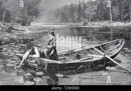 Two children in a small boat on a forest lake, the boy tries to pick a water lily, Zwei Kinder in einem Kahn auf einem Waldsee, der Junge versucht eine Seerose zu pflücken Stock Photo