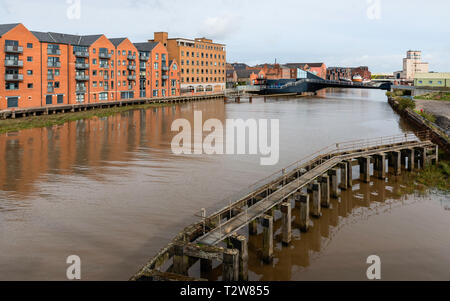 River Hull flanked by modern flats and offices, and derelict causeway  and Scale Lane bridge in Hull, Yorkshire, UK. Stock Photo