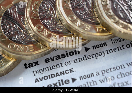 DICTIONARY DEFINITION OF TAX EVASION WITH ONE POUND COINS RE PENSIONS TAX HMRC ETC UK Stock Photo