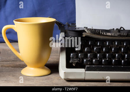 Old typewriter with coffee cup Stock Photo