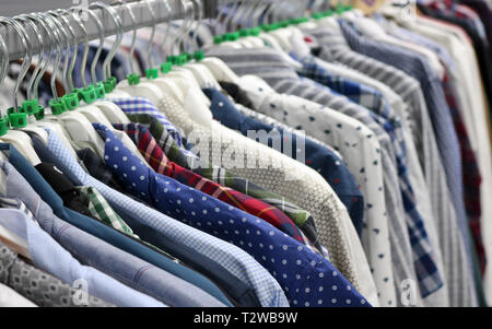 Elegant shirts on hangers in the store blurred. On the eve of Black Friday. Background for design from a department store. Stock Photo