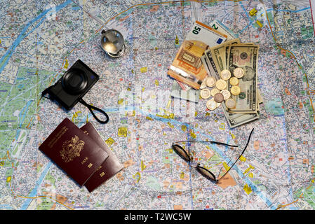 Sunglasses, a glass globe, passports,  camera and money on a tourist map background. Tourism concept. Stock Photo