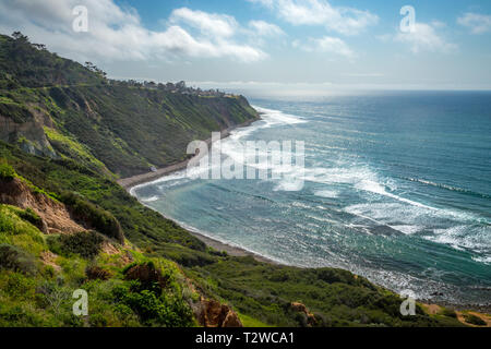 Scenic coastal view of tall cliffs of Bluff Cove covered with vegetation on a sunny spring day with  turquoise colored water and rocky beach, Blufftop Stock Photo