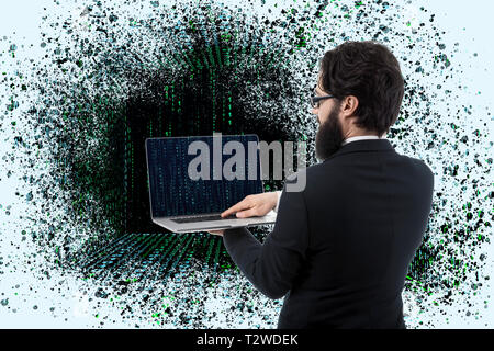 Back view of a standing programmer holding and using laptop with binary code, man opens a portal to cyber reality Stock Photo