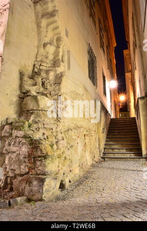 Alleyway, a narrow side street as a passage and connecting path between Grünangergasse and Blutgasse with old walls in the historic city of Vienna. Stock Photo