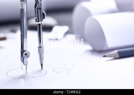 rolls of blueprints, drawing compass and graphical architectural plan. several drawing tools Stock Photo