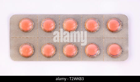 Pink pills in silver plastic pack - blister. Global pharmaceutical industry for billions dollars per year. Pharmaceutical drugs for use as medications Stock Photo