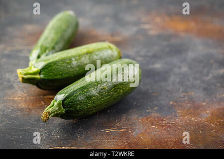 Three fresh zucchini squash on a wooden cutting board Stock Photo