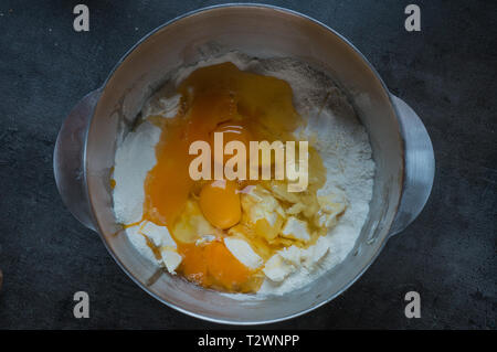 broken eggs in a bowl with baking powder, ready to be mixed Stock Photo