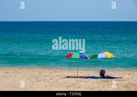 Two colorful umbrellas on white sand beach. Stock Photo
