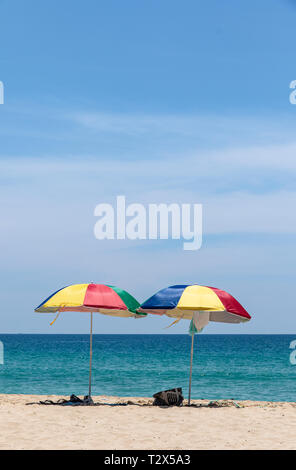 Two colorful umbrellas on white sand beach. Stock Photo