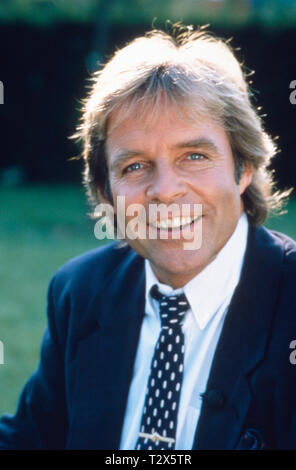 Der deutsche Film- und Fernsehschauspieler, Synchronsprecher und Schlagersänger Thomas Fritsch posiert in einem Garten im jahr 1989. The German film and television actor, voice actor and pop singer Thomas Fritsch poses in a garden in 1989 Stock Photo