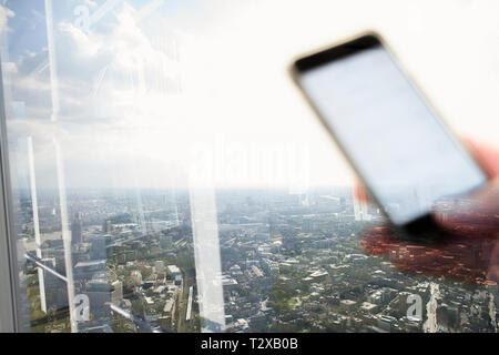 Reflection of a businessman on the phone with a cityscape behind Stock Photo