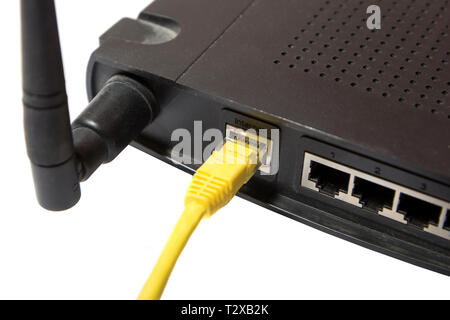 wireless router with yellow internet cable on white background Stock Photo
