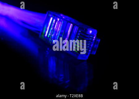 Network connection plug with fiber optics cable isolated on black background Stock Photo
