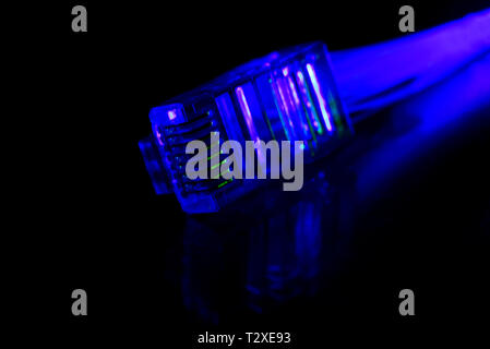 Network connection plug with fiber optics cable isolated on black background Stock Photo
